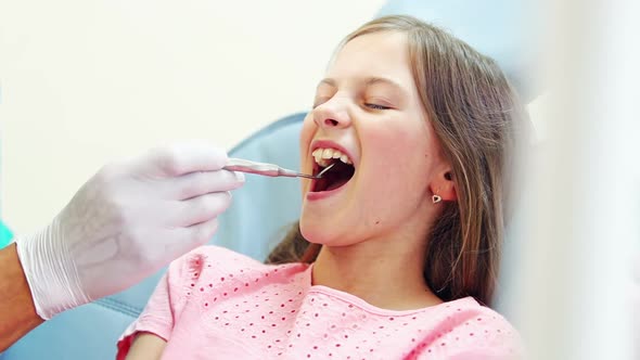 Close up of cute girl having a dental checkup with mouth mirror