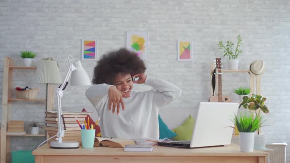 African American Woman with an Afro Hairstyle Listening To Music with Headphones and Dancing