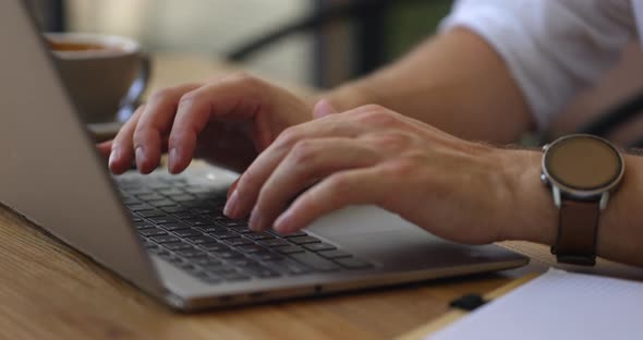 Close Up of Hands of Businessman Busy While Using Laptop in the Cafe