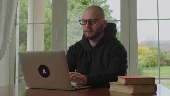 30s Concentrated Man Typing on Laptop