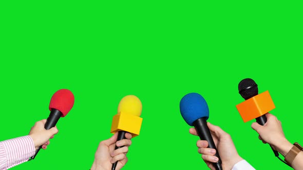 Microphones in the Hands of Journalists for Interview on Green Screen Background