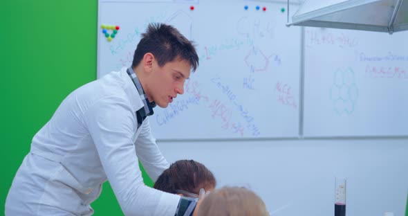 Teacher Explaining an Experiment to a High School Chemistry Class Together