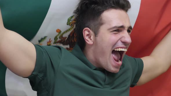 Mexican Young Man celebrating while Holding the Flag of Mexico