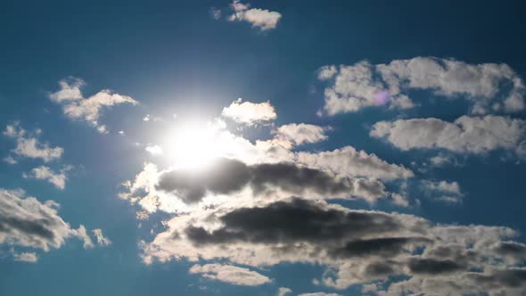 Clouds Move Smoothly in the Blue Sky on Background of Bright Sun. Timelapse