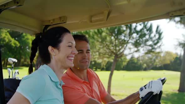 Two golfers driving in their golf buggy