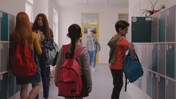 Children Walk in School Hallway Boy Closes His Locker