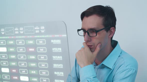 Young Man Trader Using Futuristic Interface and Browsing Online in Trading Office