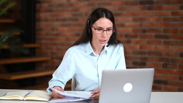 Irritated Angry Caucasian Business Woman with Headset Conducts a Meeting with Colleagues Online