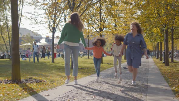 Happy Homosexual Family with Two African Daughters Playing Together in Park