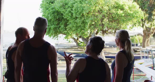 Four senior caucasian men and women standing by a river talking