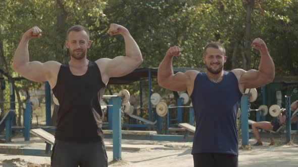 Cheerful Bodybuilders Showing Double Biceps Pose