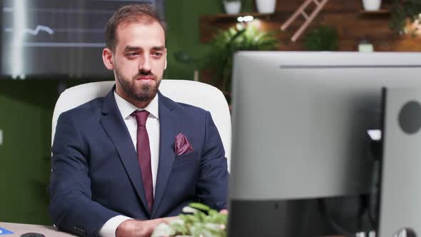 Confident Office Worker Typing on the Computer and Smiling