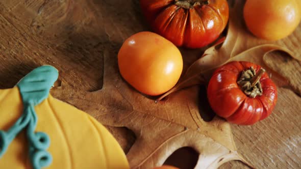 Small pumpkins, tomatoes and sweet food on a wooden table 4k