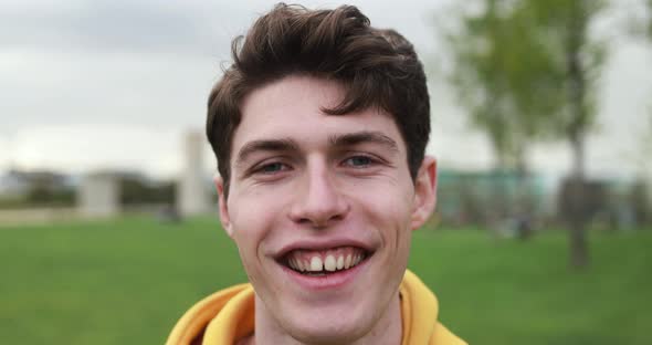 Young caucasian man smiling on camera outdoor