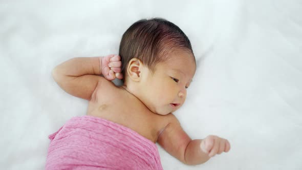 newborn baby lying on a bed