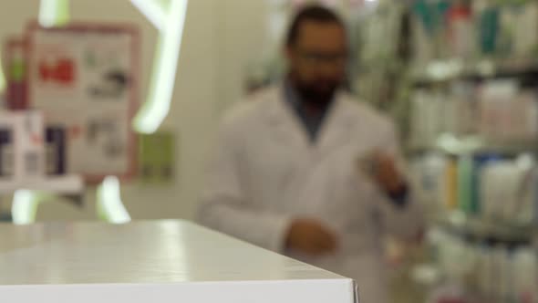 Pharmacist Putting Blisters of Pills on the Counter Working at His Drugstore