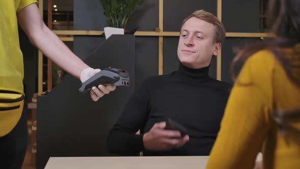 Portrait of Handsome Successful Businessman Paying with Smartphone in Restaurant