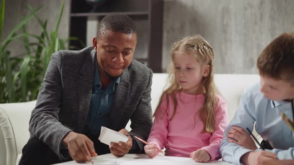 Black Teacher Shows Cards Telling Letter Names to Children