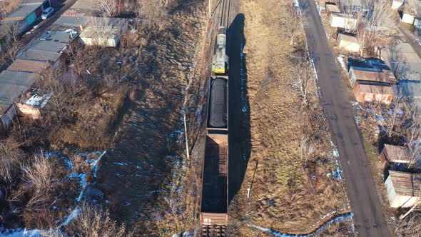 Train on railroad from above. Aerial view of train on railway track through countryside