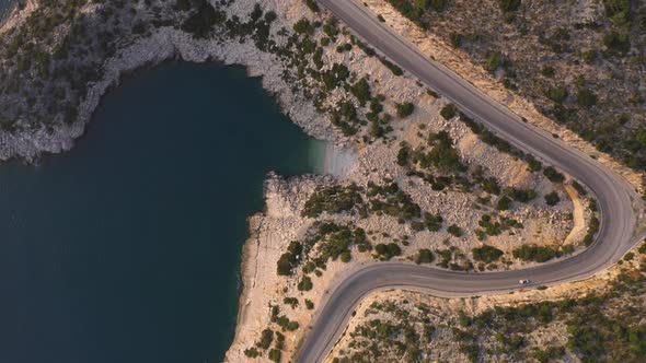 Aerial Drone View of Curvy Asphalt Road Along Sea and Mountains