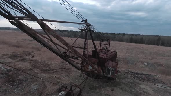 FPV Drone Flies Smoothly Near Rusty Abandoned Walking Excavator