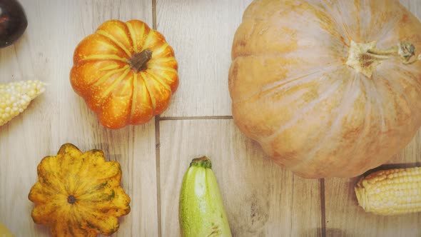 Autumn vegetables on wooden background. Pumpkins and corn, top view.