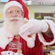 Santa Claus doing grocery shopping at the supermarket, he is showing a mini cart - VideoHive Item for Sale