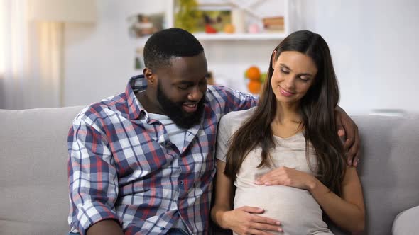 Mixed-Race Family Looking at Camera, Pregnant Woman Holding Tummy, Happiness