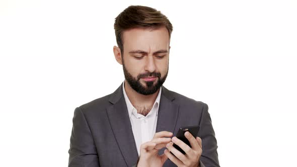 Portrait of Attractive Man Scrolling News Feed in His Social Network Using Modern Mobile Device