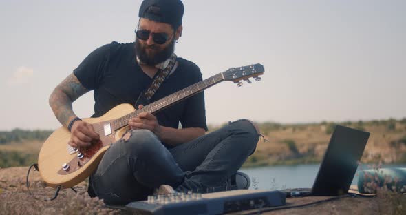 Musician Plays Electric Guitar and Use Electronics