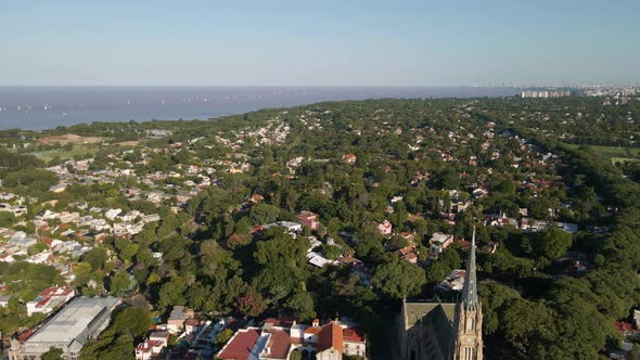 Aerial parallax shot of residential neighborhood in San Isidro and Buenos Aires city on background