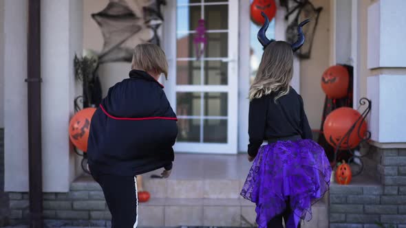 Live Camera Follows Cheerful Boy and Girl in Halloween Costumes Running Entering Decorated House on