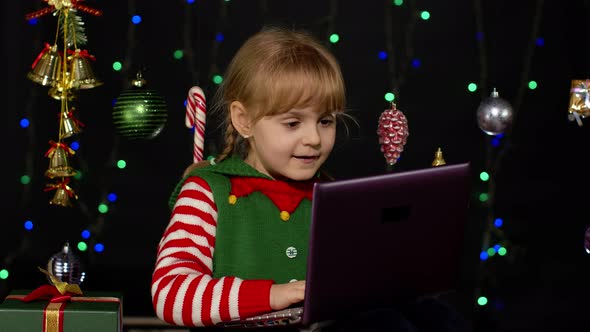 Kid Girl Christmas Elf Costume Doing Shopping Online Using Laptop Browsing Social Media