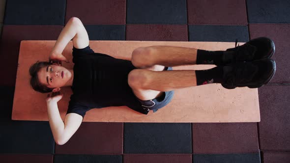 Young Male Athlete Shakes the Press Tense Abdominal Muscles