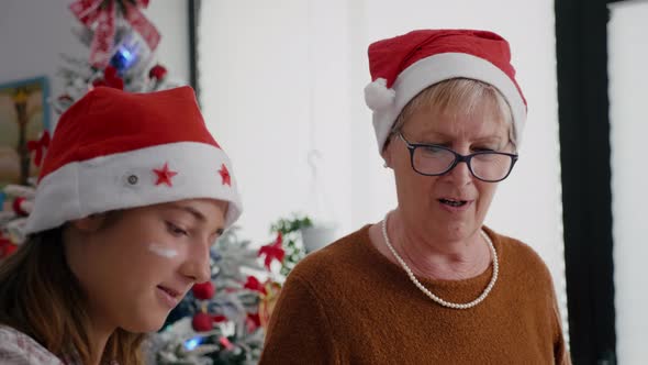 Portrait of Grandmother with Granddaughter Wearing Santa Hats