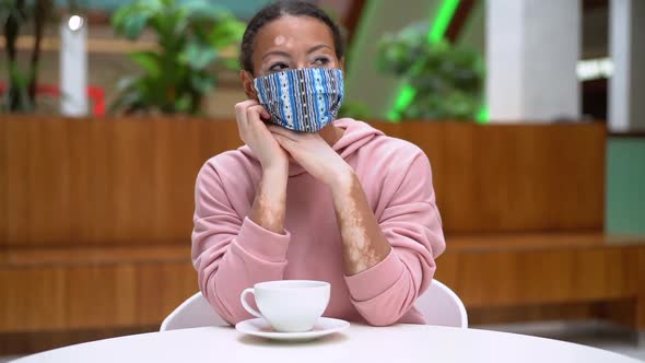 Black African American Woman with Vitiligo Pigmentation Skin Problem Indoor Dressed Pink Hoodie and