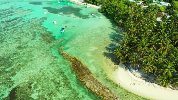 Aerial top down seascape of marine island beach adventure by turquoise lagoon and white sand backgro