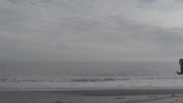 A young woman running on the beach.