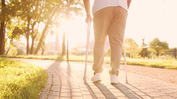 Disabled African-American man is walking with a walker. Patient in the park.