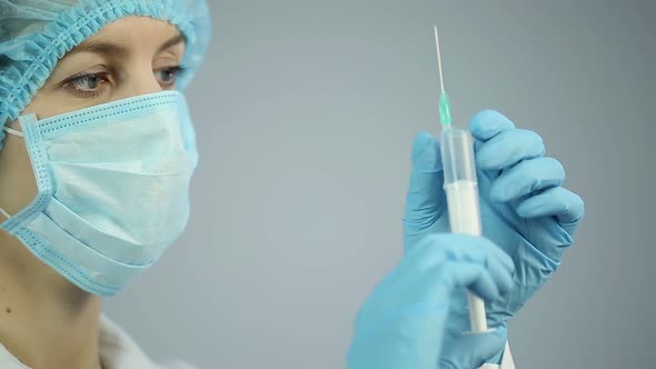 Surgical Nurse Focused on Syringe With Medicine for Patient