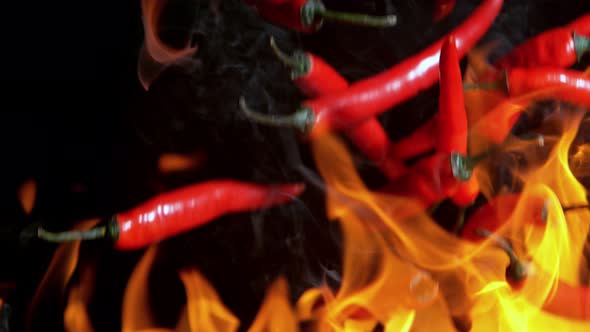 Super Slow Motion Shot of Falling Red Chilli Peppers to Fire at 1000Fps
