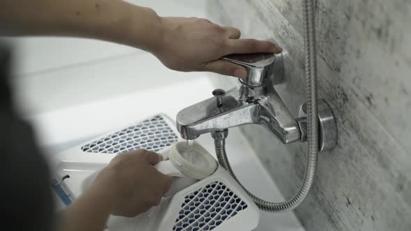 Female Hands Put Vacuum Cleaner's Capacity Under Faucet with Water