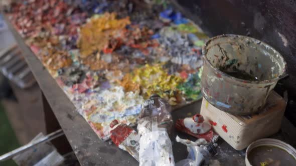 Close-up tilt-up shot reveals tools and workspace in an artist's workshop