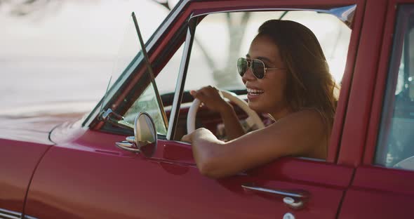 Two girl friends having fun in their vintage car