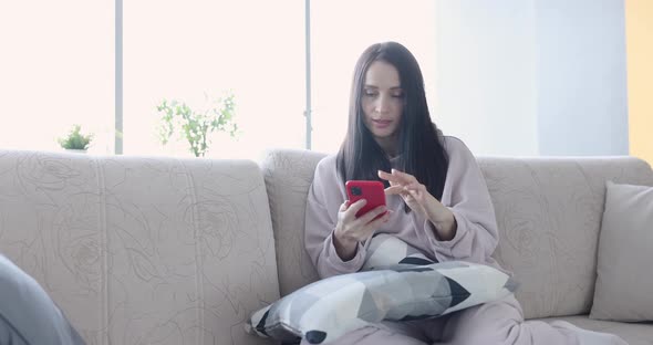 Woman Sitting on Sofa with Mobile Phone and Smiling  Movie