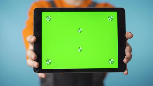 Unrecognizable Repairman Holding Tablet with Green Screen Against Camera