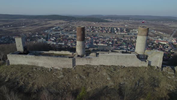 A tracking aerial drone shot of the Chęciny Royal Castle whileing upward towards the right. This is