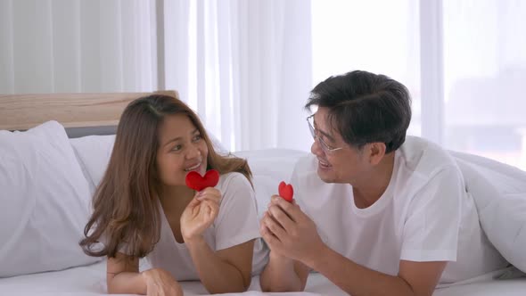 Happy Asian senior couple laying down in the bedroom