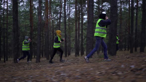 Group of Volunteers in Green Vests Went in Search of Missing Persons in a Pine Forest