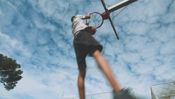 Black guy throwing basketball ball into ring